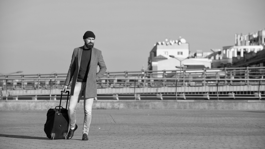 Business trip. Man bearded hipster travel with big luggage bag on wheels. Let travel begin. Traveler with suitcase arrive to airport railway station. Hipster ready enjoy travel. Carry travel bag.